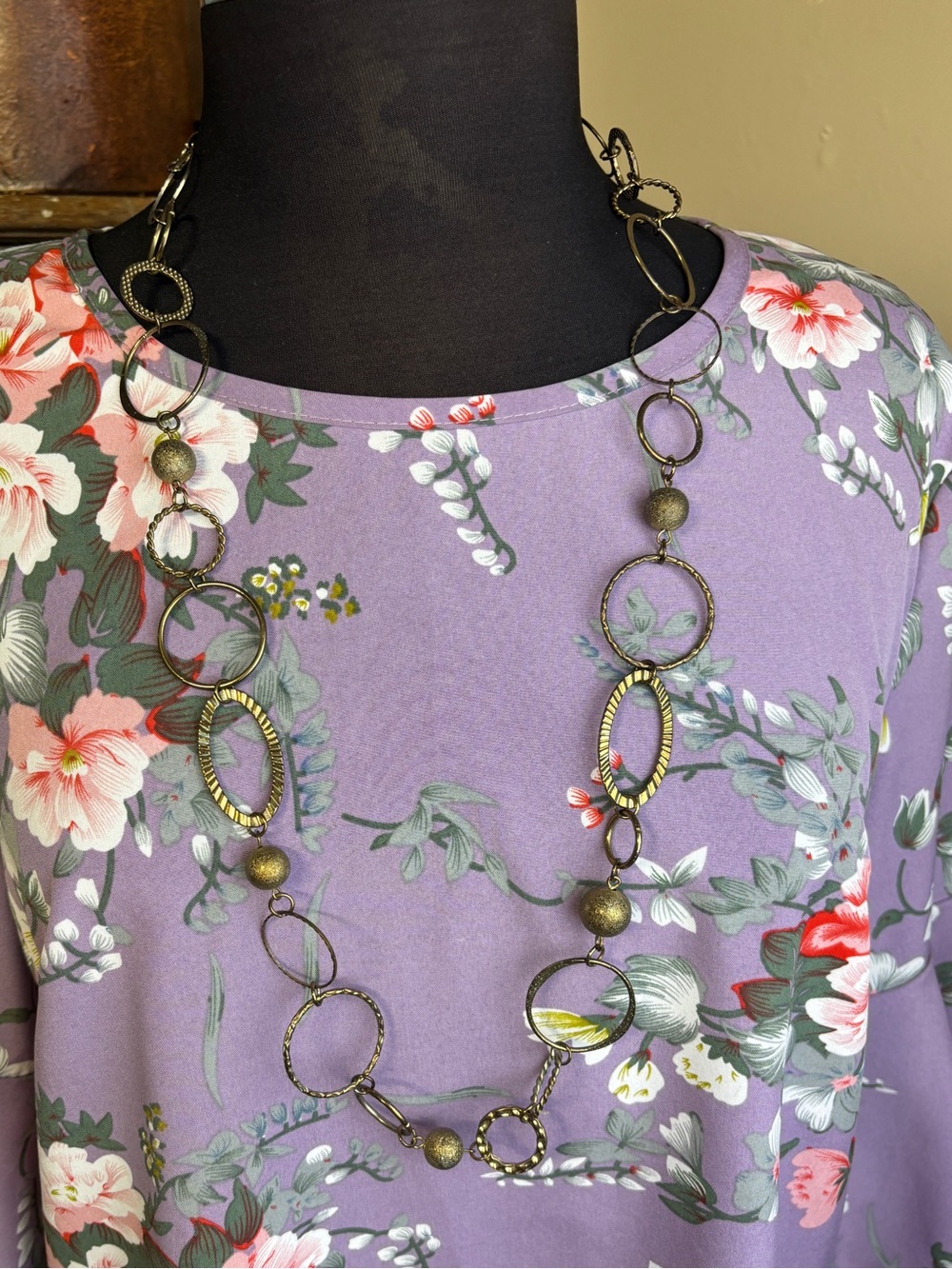 Mixed metal necklace with textured hoops, open rings & beaded details, 32”w 3”ex